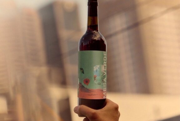 Hand holding up a wine bottle.