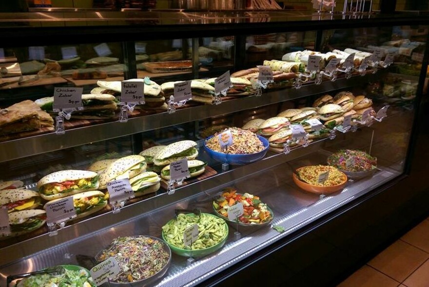 Counter full of sandwiches, panini and salads.