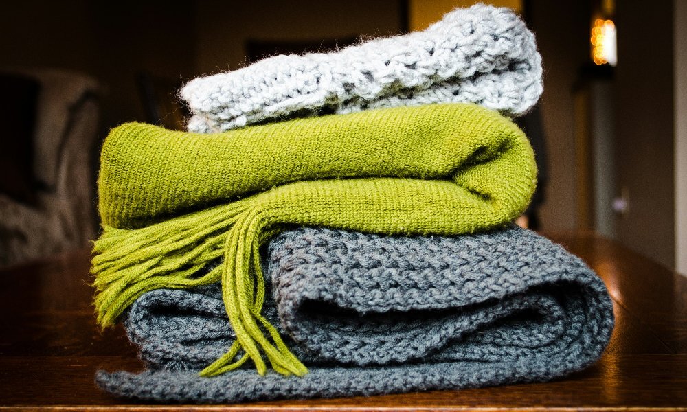 A stack of different coloured scarves.