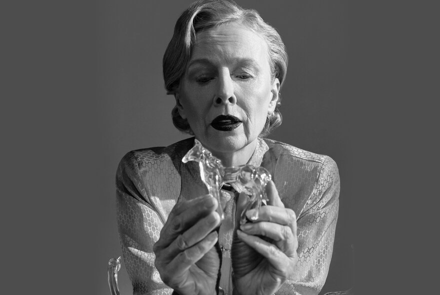 Actress Alison Whyte portraying a character in the play The Glass Menagerie, holding a small glass figurine; black and white photo.