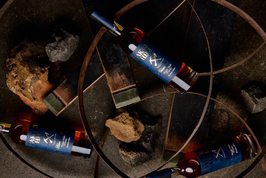 Bottles of whisky displayed against ochre coloured rocks.