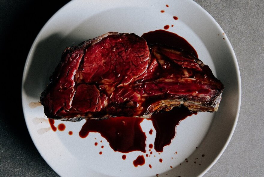 A bloodied plate of only steak. 