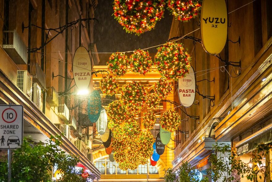 A laneway filled with decorations hanging.