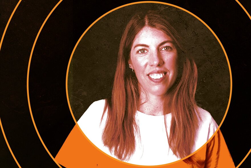 Comedian Alex Ward smiling, wearing a white t-shirt and posed against a black background, with thin orange rings circling her portrait.