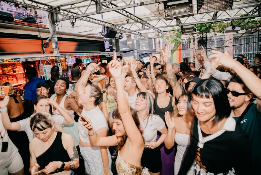 A crowd of people dancing to music at Section 8, a shipping container bar in Melbourne.