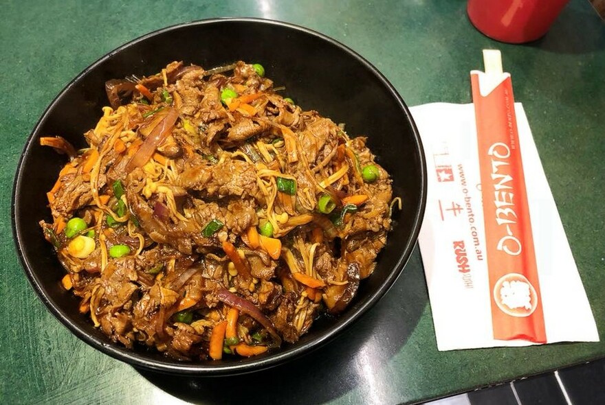 Bowl of noodles with chopsticks.