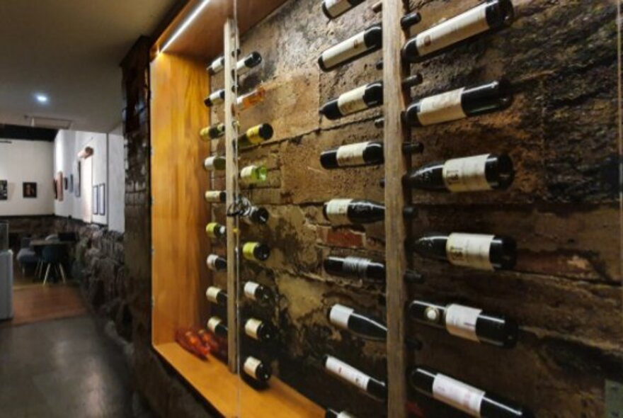Interior of Life's Too Short Bar, with a rack of wine bottles displayed against an exposed brick wall.