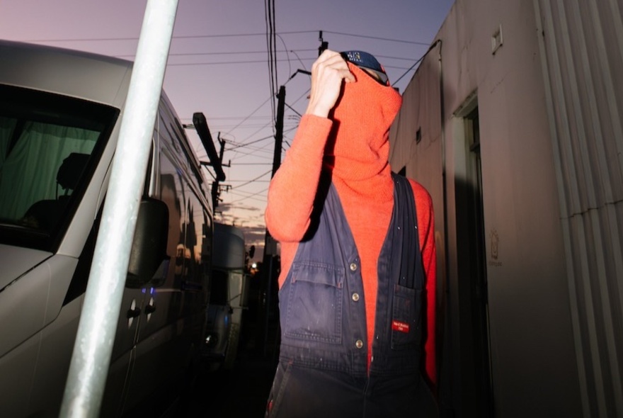 Portrait of a person hiding their face in their jumper.
