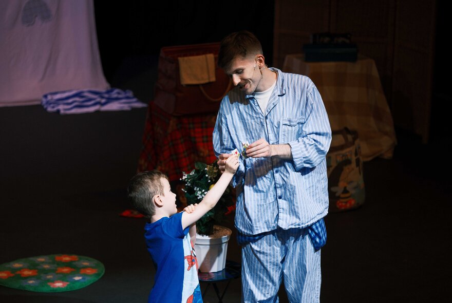 A man and a child in pyjamas, on stage.