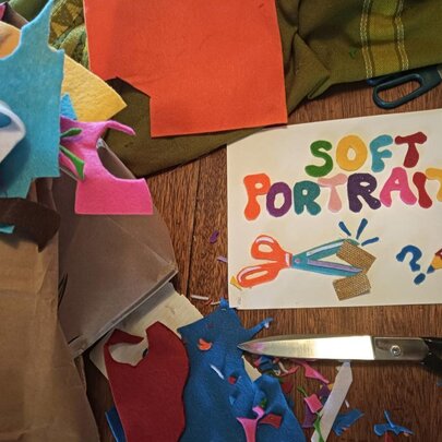 Chopped up pieces of coloured felt and a poster that says 'soft portraits' made more the material. 