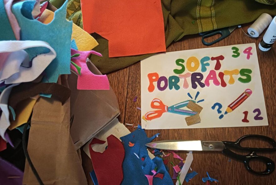 Chopped up pieces of coloured felt and a poster that says 'soft portraits' made more the material. 