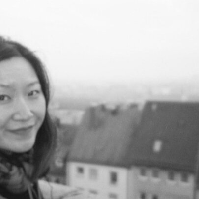 Woman with European town scene with houses in the background.