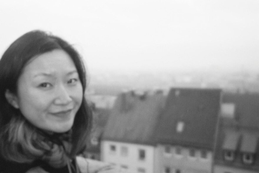 Woman with European town scene with houses in the background.