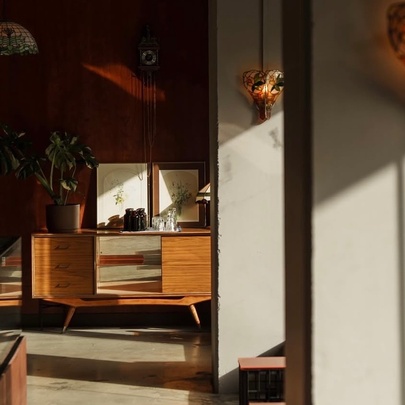 Japanese-inspired cafe interior with wooden counter and benches, soft wall light sconces.