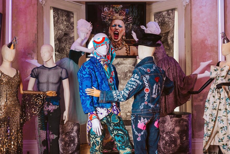 Male mannequins dressed extravagently in embroidered denim outfits.