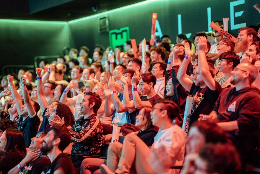 A live audience cheering in the arena at Fortress while watching a live gaming performance.