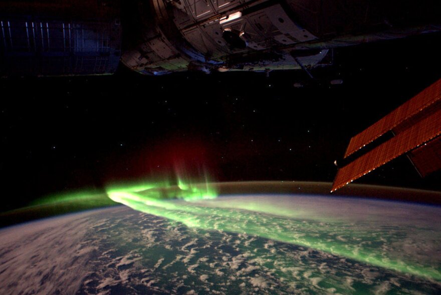 The greenish Northern Lights spreading across earth's atmosphere, seen from the International Space Station.