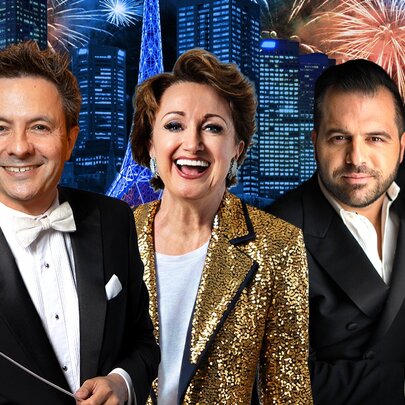 Three entertainers in formal attire in front images of the Melbourne skyline and fireworks. 