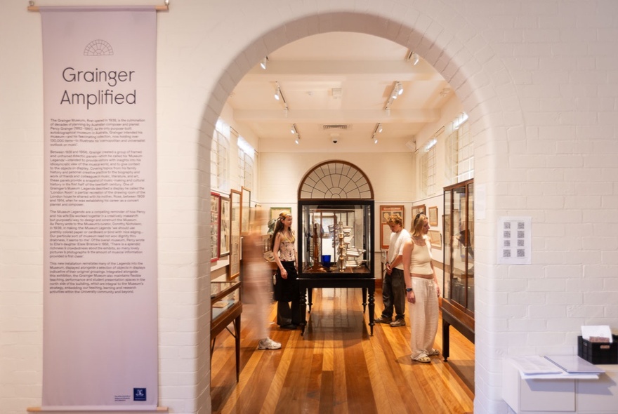 Museum display of cabinets viewed through an arched doorway.