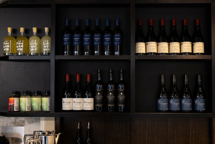 Dark shelves in a restaurant filled with wine. 