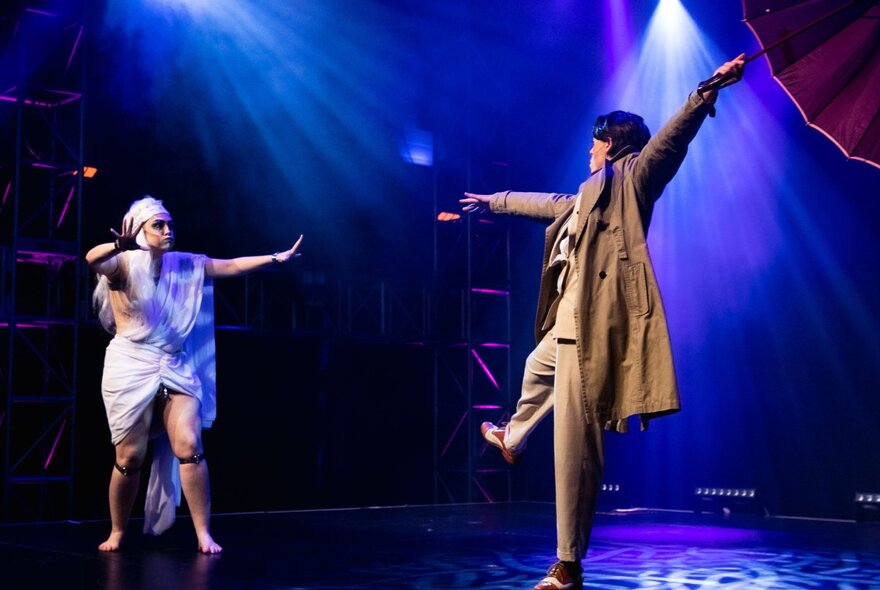 Two burlesque dancers performing on stage under blue lights. 