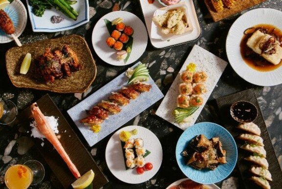 An array of Japanese foods on platters, seen from above.