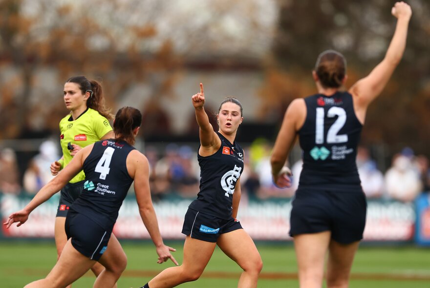 Carlton Blues AFLW players celebrating a goal on the field.