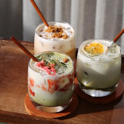Three iced drinks on a wooden serving platter.