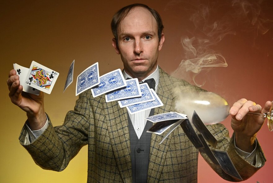 Dane Certificate, an award-winning magician flicking a deck of playing cards from one hand to the other.