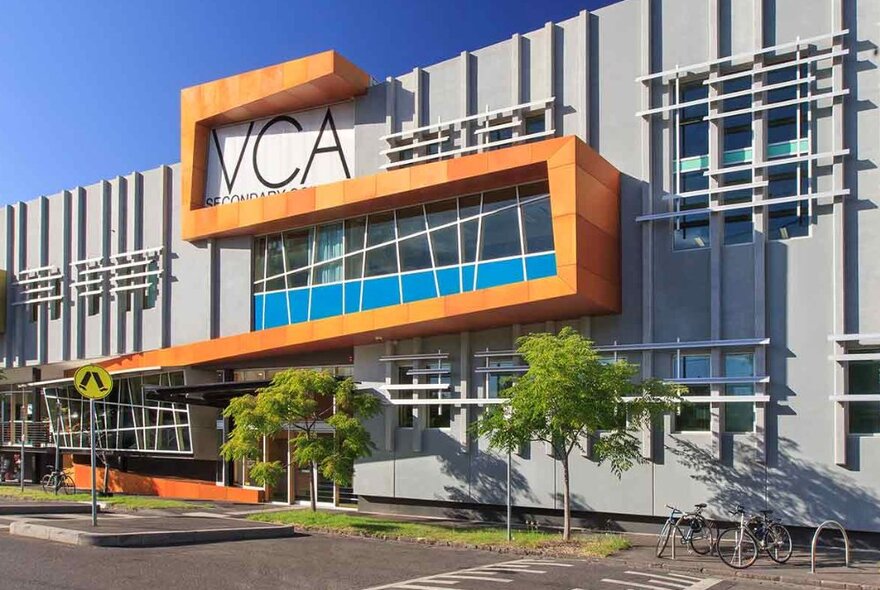 Victorian College of the Arts school building with signage, exterior cladding design and street trees.