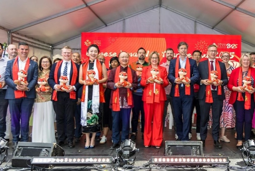 Rows of people holding flowers standing on a stage.