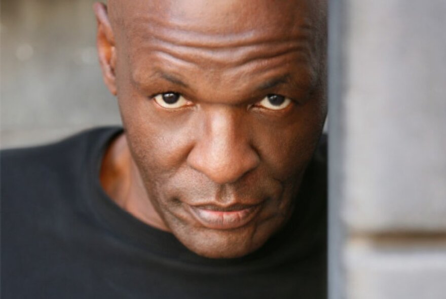 A head shot of singer Steve Clisby looking directly ahead from a doorway.