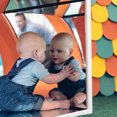 Baby looking in a mirror.