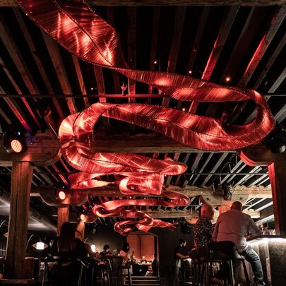 Red lighting that appears as a ceiling thread against a dark background. 