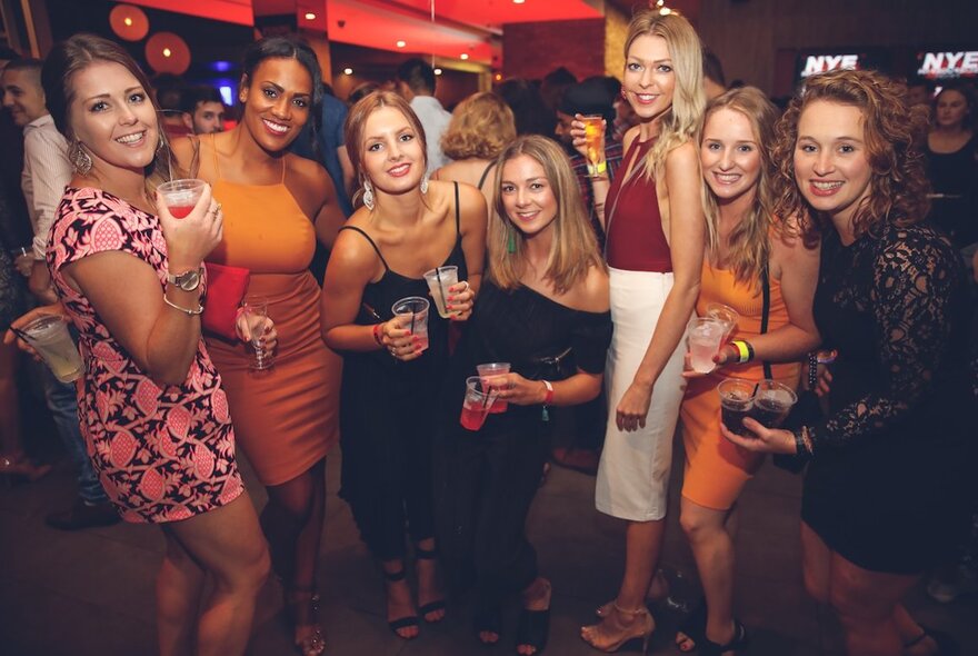 A group of people posing for a photograph in a nightclub.