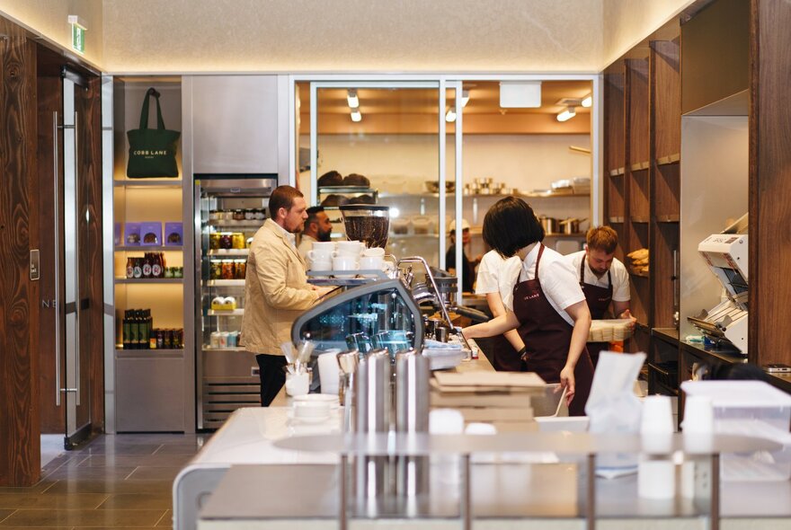 The interior of a high-end bakers with bakers in aprons. 