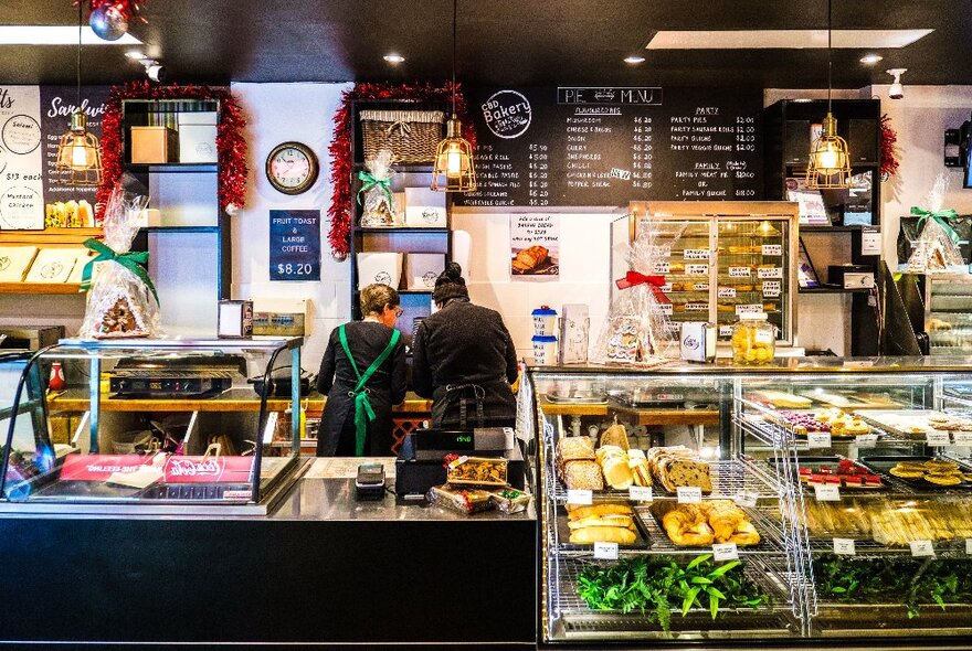 The counter and glass display cabinets at CBD Bakery with a menu hanging on the rear wall.