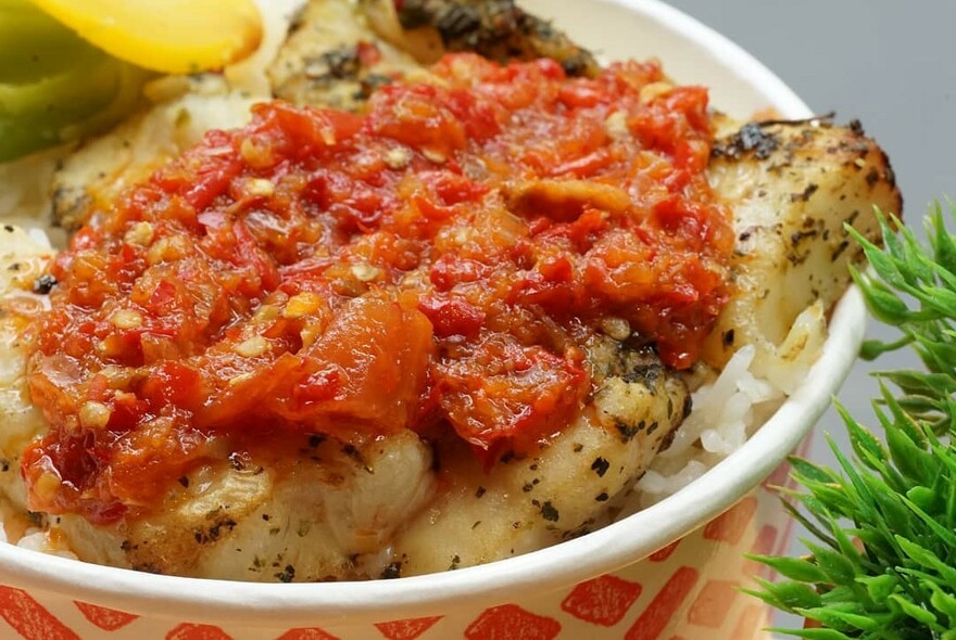 Bowl of Indonesian street food with cooked tomato on top.