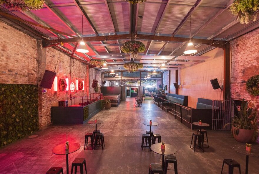 An empty warehouse space with chairs and tables.