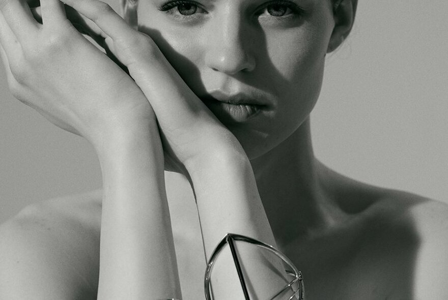 Black and white close up of a woman wearing a metal bangle 