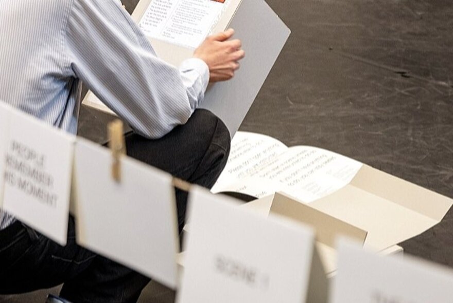 A person reading a box with signs in the foreground.
