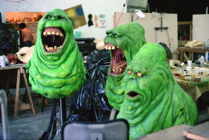 A still image from a film showing three laughing green, wrinkly monsters. 