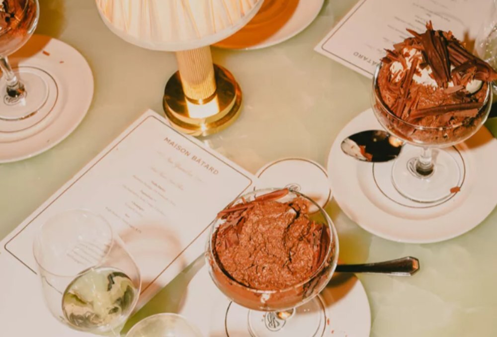 A restaurant table with two chocolate mousse desserts served in glasses.