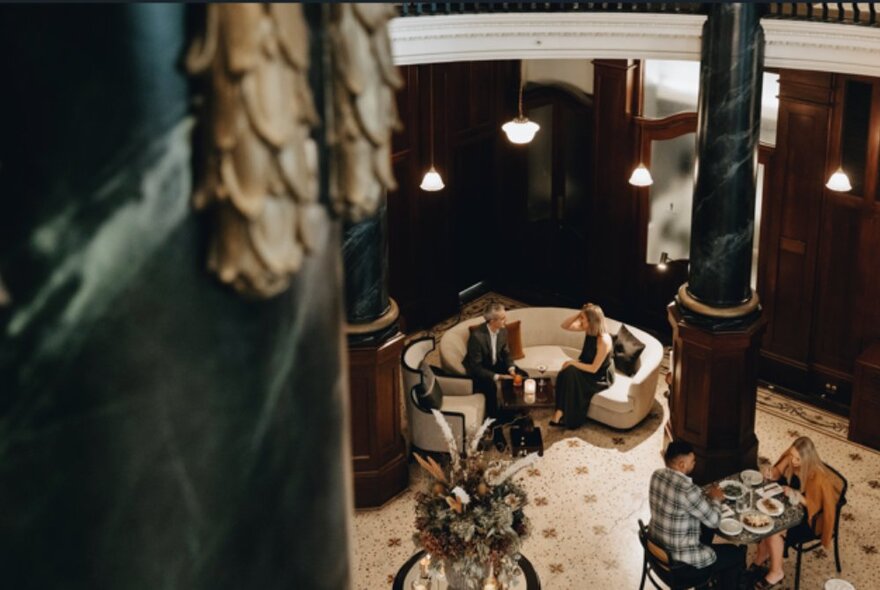 A high perspective of diners in the Atrium at the Rendezvous Hotel in Melbourne, with a patterned floor and opulent finishes.