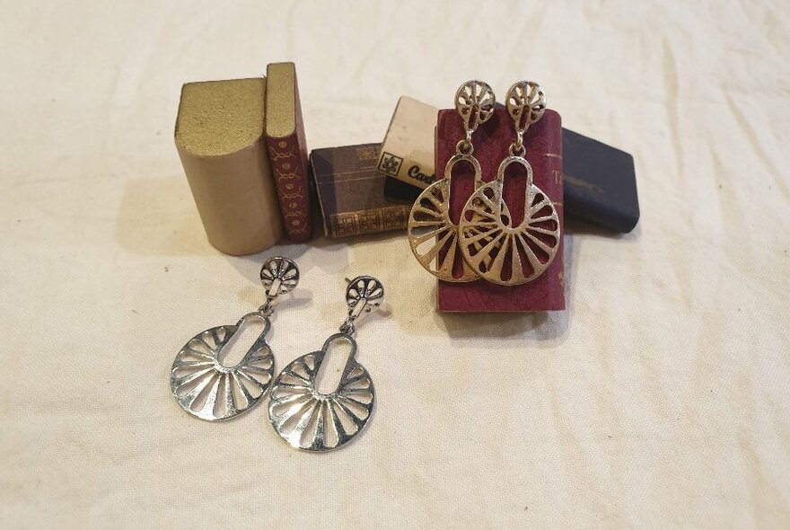 Silver and copper coloured earrings displayed on a white background.