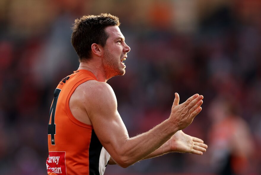 GWS captain Toby Greene clapping his hands and looking mean. 