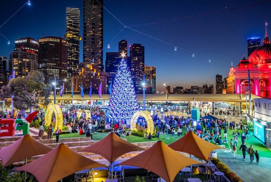 Christmas tree and decorations at Fed Square at night. 