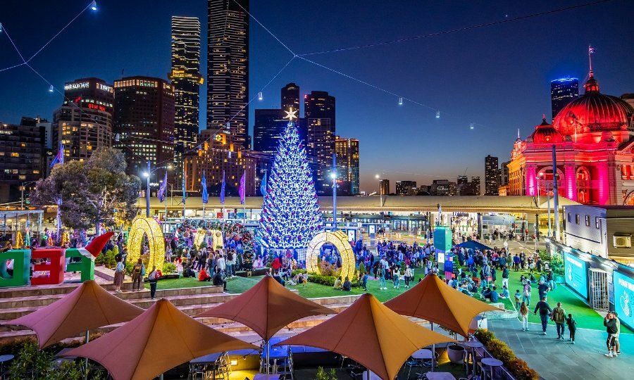 Christmas tree and decorations at Fed Square at night. 