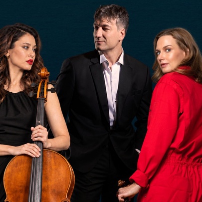 Three musicians, one holding a cello.