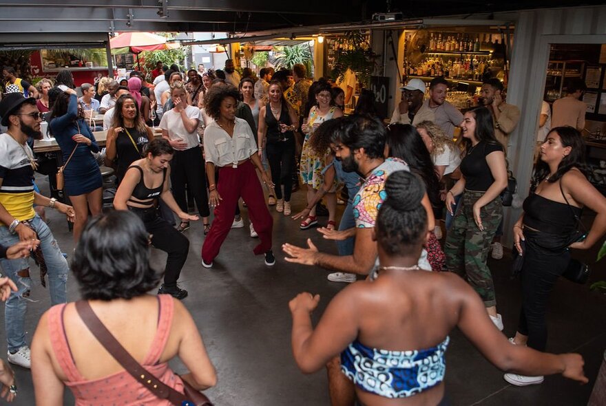 Musicians, dancers and crowd dancing in a small venue.